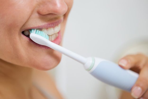electric toothbrush benefits (1) individual using electric toothbrush benefits