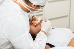 dentist performing tooth removal for impacted teeth