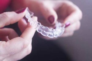 hands holding clear aligners