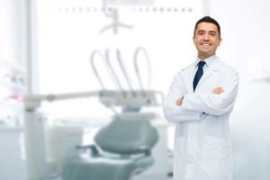 dentist with arms crossed smiling about restorative dentistry