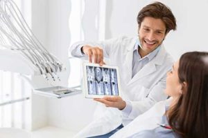 a dentist discusses orthodontics with his patient